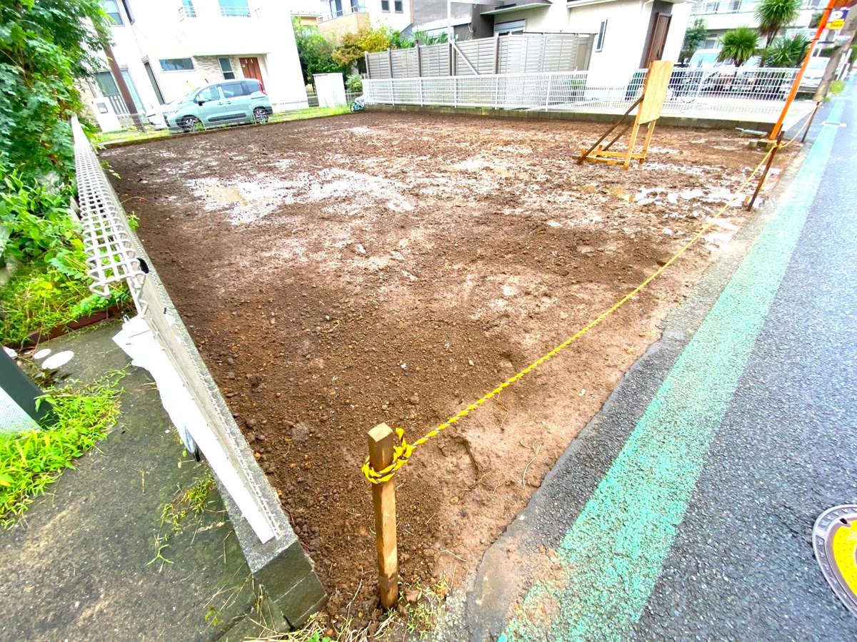 道路側の角から見た敷地。奥に隣家